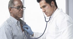 Doctor using stethoscope on patient